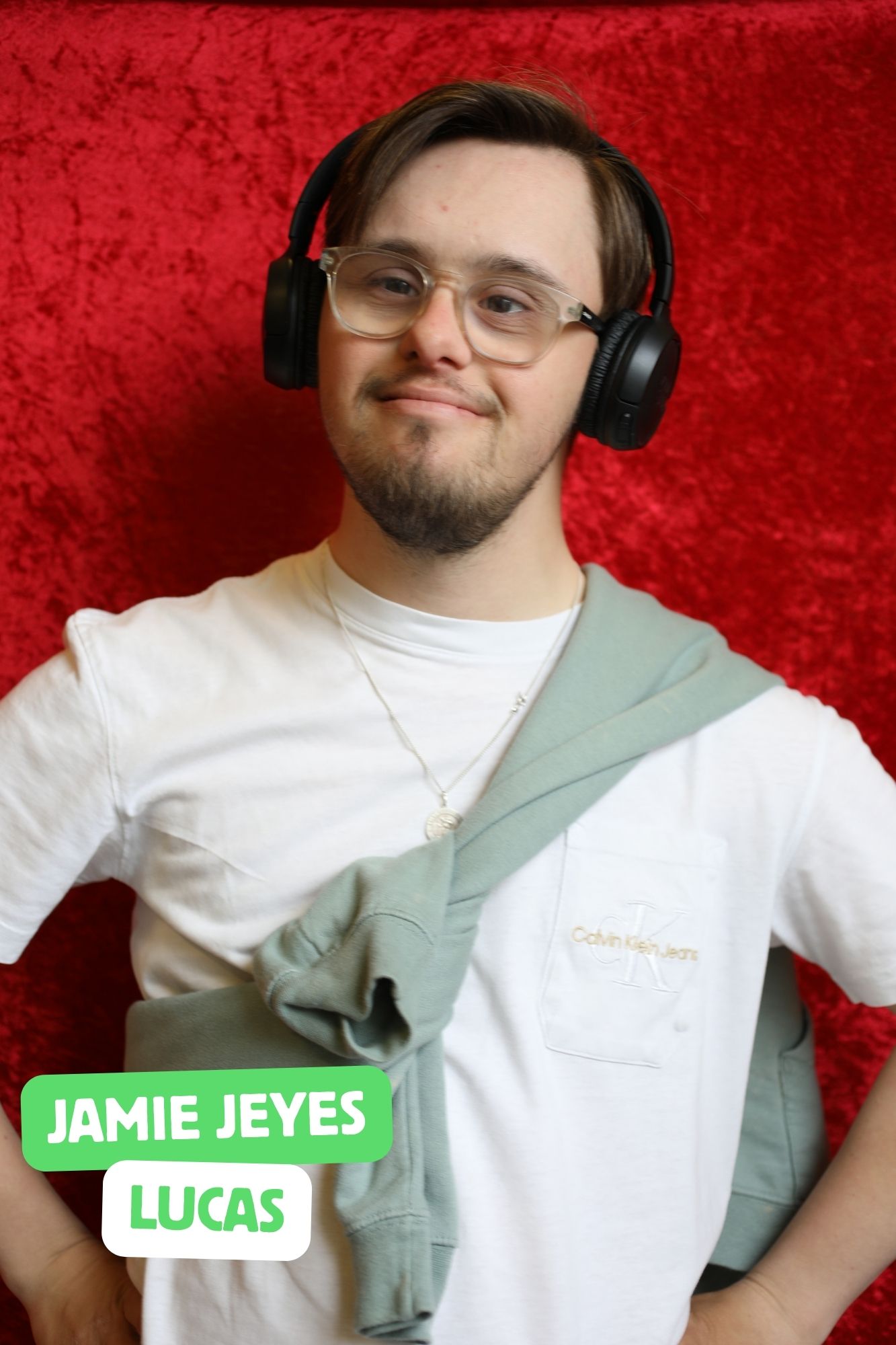 Jamie, a white man who has Down’s Syndrome is playing Lucas. He is wearing a white t-shirt and colourful jogging bottoms.
